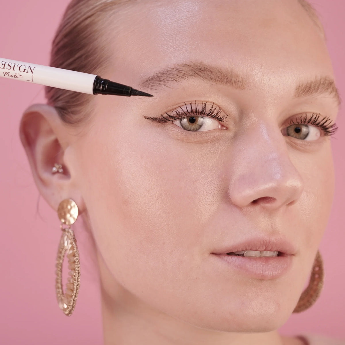 Frau zieht mit dem EYELINER von DESI'GN MADE einen Lidstrich am oberen Wimpernkranz